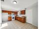 Well-lit kitchen features wooden cabinetry, white appliances, and tiled floors for easy maintenance at 1543 Sarah St, Lake Wales, FL 33898