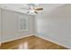 A bright bedroom with hardwood floors, a window with shutters, and a ceiling fan at 1570 Barking Deer Cv, Casselberry, FL 32707