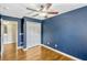 Bedroom with hardwood floors, a ceiling fan, and a closet off the adjacent bathroom at 1570 Barking Deer Cv, Casselberry, FL 32707