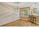 A dining room features wood floors, large window, and a view of the kitchen at 1570 Barking Deer Cv, Casselberry, FL 32707