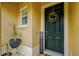 Welcoming front door is adorned with a wreath and potted plants at 1570 Barking Deer Cv, Casselberry, FL 32707