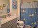 Bright bathroom features a granite-topped vanity and a cheerful shower curtain at 1596 Park Side Ave, Kissimmee, FL 34744