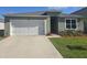 Charming single-story home featuring a well-manicured lawn, two car garage, and inviting front entrance at 1596 Park Side Ave, Kissimmee, FL 34744