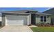 Charming single-story home featuring a well-manicured lawn, two car garage, and inviting front entrance at 1596 Park Side Ave, Kissimmee, FL 34744