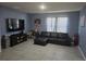 This spacious living room boasts a neutral-colored tile flooring and large TV at 1596 Park Side Ave, Kissimmee, FL 34744