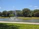 Picturesque pond with a fountain, surrounded by lush greenery for a serene community atmosphere at 1596 Park Side Ave, Kissimmee, FL 34744
