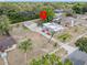 Aerial perspective of a home with detached garage nestled in a verdant, tree-filled neighborhood at 16 E Orange Street St, Davenport, FL 33837