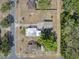 Aerial shot of a house, detached garage, and expansive property surrounded by lush trees at 16 E Orange Street St, Davenport, FL 33837