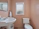 Traditional bathroom features a pedestal sink, tiled floors, and a window for natural lighting at 16 E Orange Street St, Davenport, FL 33837