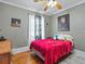 Charming bedroom with hardwood floors, a cozy bed, and decoratively painted walls at 16 E Orange Street St, Davenport, FL 33837