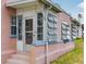 Enclosed porch with multiple windows on a quaint pink home's entrance at 16 E Orange Street St, Davenport, FL 33837