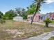 Single-story home with pink exterior, detached garage, and mature trees in a spacious yard at 16 E Orange Street St, Davenport, FL 33837