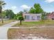 Pink house with unique window designs and a well-manicured lawn with palm trees at 16 E Orange Street St, Davenport, FL 33837