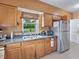 Bright kitchen boasts wood cabinets, a stainless steel refrigerator, and a view of the garden at 16 E Orange Street St, Davenport, FL 33837