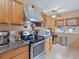 Well-lit kitchen with stainless steel oven and stove, granite countertops, and oak cabinets at 16 E Orange Street St, Davenport, FL 33837