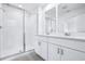 Bathroom with double sink vanity, walk-in shower and white tile at 16395 Bird Of Paradise Ave, Clermont, FL 34714