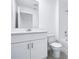 Modern bathroom featuring vanity with storage, toilet, and shower over tub, all in white at 16395 Bird Of Paradise Ave, Clermont, FL 34714