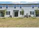 A modern townhome featuring neutral siding, a well-maintained lawn, and an inviting outdoor space at 16395 Bird Of Paradise Ave, Clermont, FL 34714