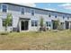 The backyard of this townhome has a neatly kept lawn and a light-colored siding at 16395 Bird Of Paradise Ave, Clermont, FL 34714