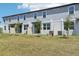 Townhome exterior showcases a well-manicured lawn, with visible air conditioning units and small privacy fences at 16395 Bird Of Paradise Ave, Clermont, FL 34714
