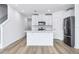 Kitchen features a center island, stainless refrigerator, and all white finishes at 16395 Bird Of Paradise Ave, Clermont, FL 34714