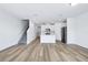 Living room with wood floors that leads to a modern kitchen and a staircase to the second floor at 16395 Bird Of Paradise Ave, Clermont, FL 34714