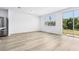 Bright living room offers wood floors, neutral paint, and a sliding glass door to the backyard at 16395 Bird Of Paradise Ave, Clermont, FL 34714