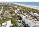 Aerial view of a coastal neighborhood showcasing lush greenery, residential houses, and the ocean coastline at 1640 N Atlantic Ave, New Smyrna Beach, FL 32169