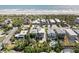 A coastal community is showcased in this aerial view, with a sandy beach along the ocean and homes surrounded by lush vegetation at 1640 N Atlantic Ave, New Smyrna Beach, FL 32169