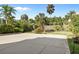 Spacious concrete backyard area with a privacy fence surrounded by lush, tropical landscaping at 1640 N Atlantic Ave, New Smyrna Beach, FL 32169