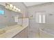 Bright bathroom featuring double sinks, jacuzzi tub, a neutral palette and decorative wallpaper at 1640 N Atlantic Ave, New Smyrna Beach, FL 32169