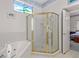Bright bathroom showcasing a glass shower, jacuzzi tub, and decorative stained glass window at 1640 N Atlantic Ave, New Smyrna Beach, FL 32169