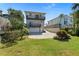 This two-story home features a light-colored exterior, complemented by upper-level balconies and a well-maintained lawn at 1640 N Atlantic Ave, New Smyrna Beach, FL 32169