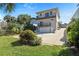 Exterior of home featuring a well-kept lawn, two-story design, and a spacious driveway leading to the garage at 1640 N Atlantic Ave, New Smyrna Beach, FL 32169