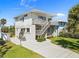 Two-story home with a light-colored exterior, complemented by a wooden staircase leading to a private upper-level balcony at 1640 N Atlantic Ave, New Smyrna Beach, FL 32169