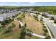 Aerial view of the neighborhood featuring sidewalks, green spaces, and a playground at 17500 Butterfly Pea Ct, Clermont, FL 34714