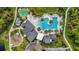 An aerial view showing the community pool, clubhouse, playground, and surrounding lush landscaping at 17500 Butterfly Pea Ct, Clermont, FL 34714