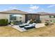 Wide angle shot of backyard featuring patio, outdoor furniture, and screened lanai at 17500 Butterfly Pea Ct, Clermont, FL 34714