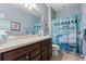 Whimsical bathroom with custom vanity, mermaid themed curtain, and ample lighting at 17500 Butterfly Pea Ct, Clermont, FL 34714