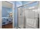 Bright bathroom highlighting a clear glass shower and a glimpse into the bedroom at 17500 Butterfly Pea Ct, Clermont, FL 34714