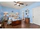 A serene bedroom featuring wood floors, a ceiling fan, and stylish decorations at 17500 Butterfly Pea Ct, Clermont, FL 34714
