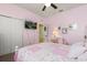 A pink bedroom with a TV on the wall and a walk in closet at 17500 Butterfly Pea Ct, Clermont, FL 34714