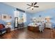 A bedroom with blue walls, a ceiling fan, and wood flooring for a cozy ambiance at 17500 Butterfly Pea Ct, Clermont, FL 34714