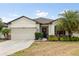 Charming single-story home with a two-car garage, manicured lawn, and a welcoming front entrance at 17500 Butterfly Pea Ct, Clermont, FL 34714