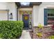 A welcoming entryway featuring a wreath on the front door and decorative plants at 17500 Butterfly Pea Ct, Clermont, FL 34714