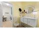 Hallway features vintage dresser and chair beside laundry room at 17500 Butterfly Pea Ct, Clermont, FL 34714