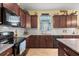 A cozy kitchen featuring granite countertops, wood cabinets, and a subway tile backsplash at 17500 Butterfly Pea Ct, Clermont, FL 34714