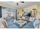 Comfortable living room with a large sectional sofa, entertainment center, and access to the patio at 17500 Butterfly Pea Ct, Clermont, FL 34714