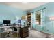 Bright home office with calming blue paint, a desk and chair, and natural light at 17500 Butterfly Pea Ct, Clermont, FL 34714