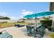 Spacious backyard patio with outdoor dining set, lounge chairs, and blue umbrella at 17500 Butterfly Pea Ct, Clermont, FL 34714